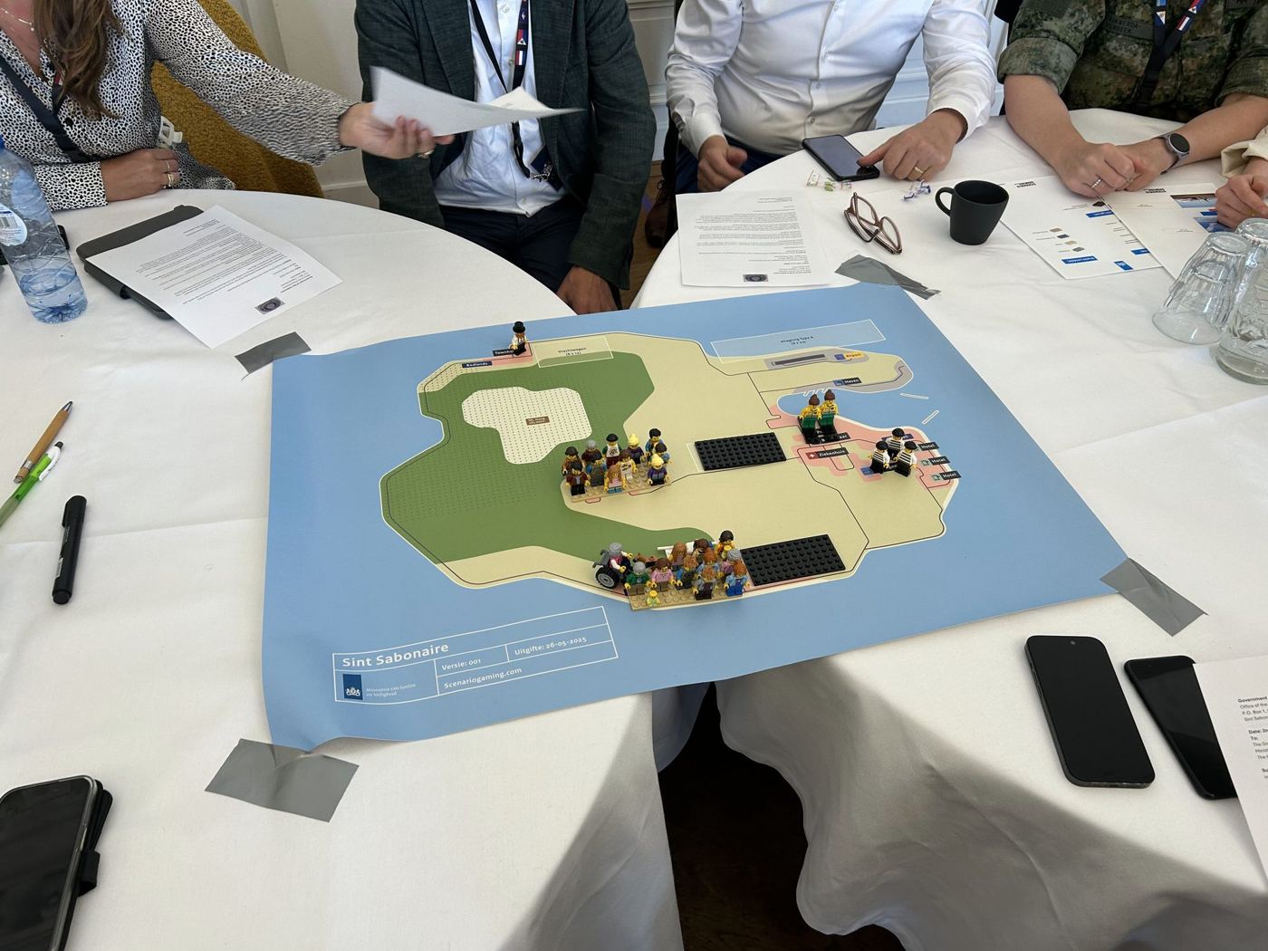 Deelnemers buigen zich over een eiland met legofiguren