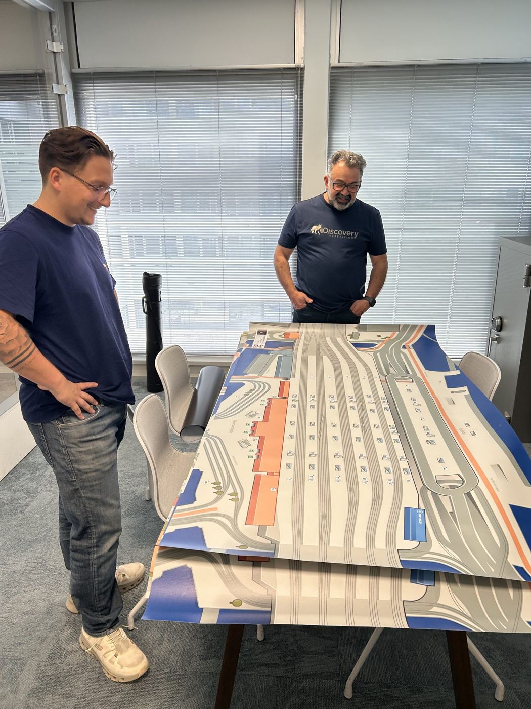 Twee medewerkers van NS bij een tafel met een spelbord van station Utrecht Centraal