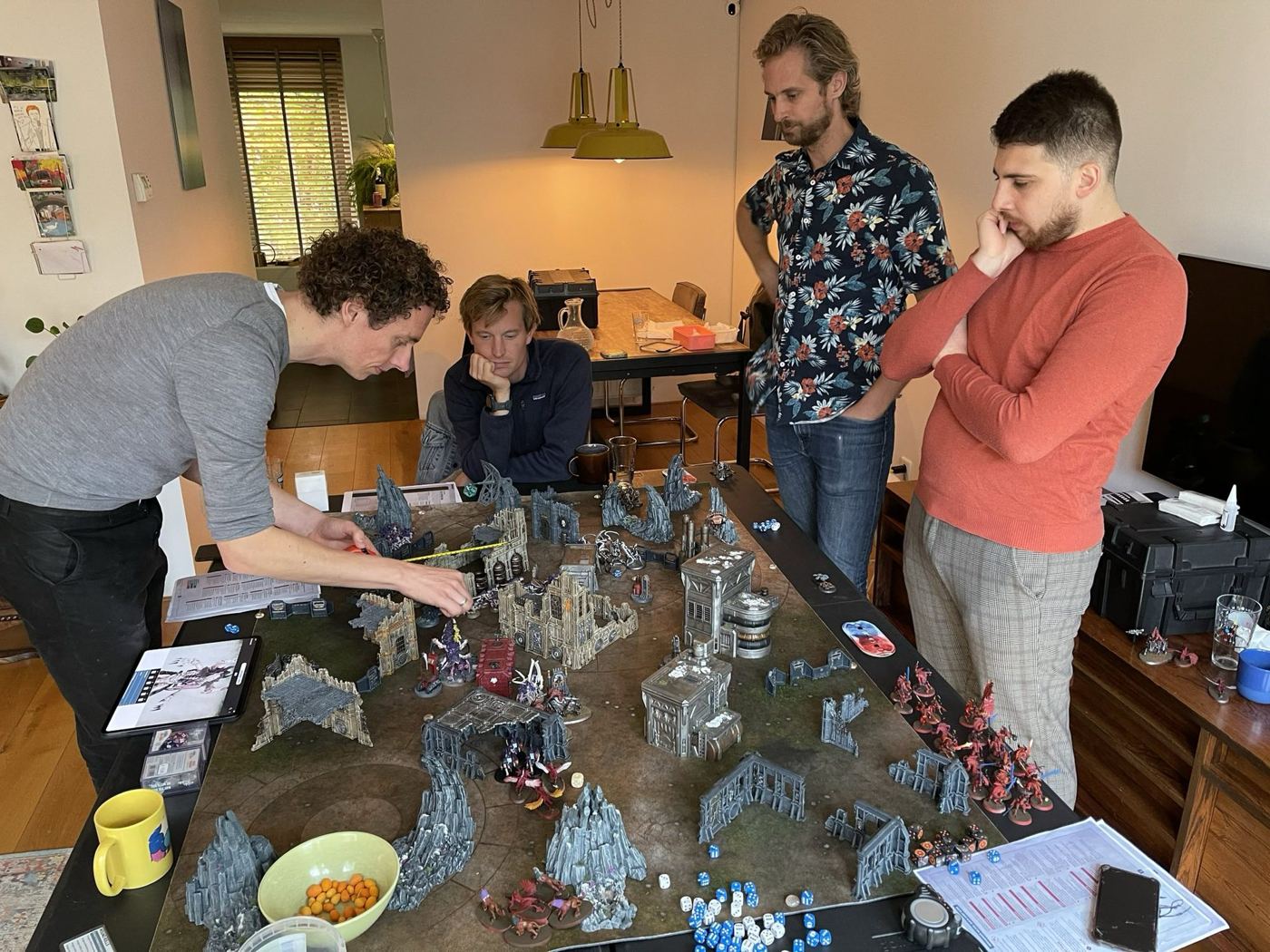 Laurens en drie anderen rond een tafel met een Warhammer 40k-slagveld vol miniaturen
