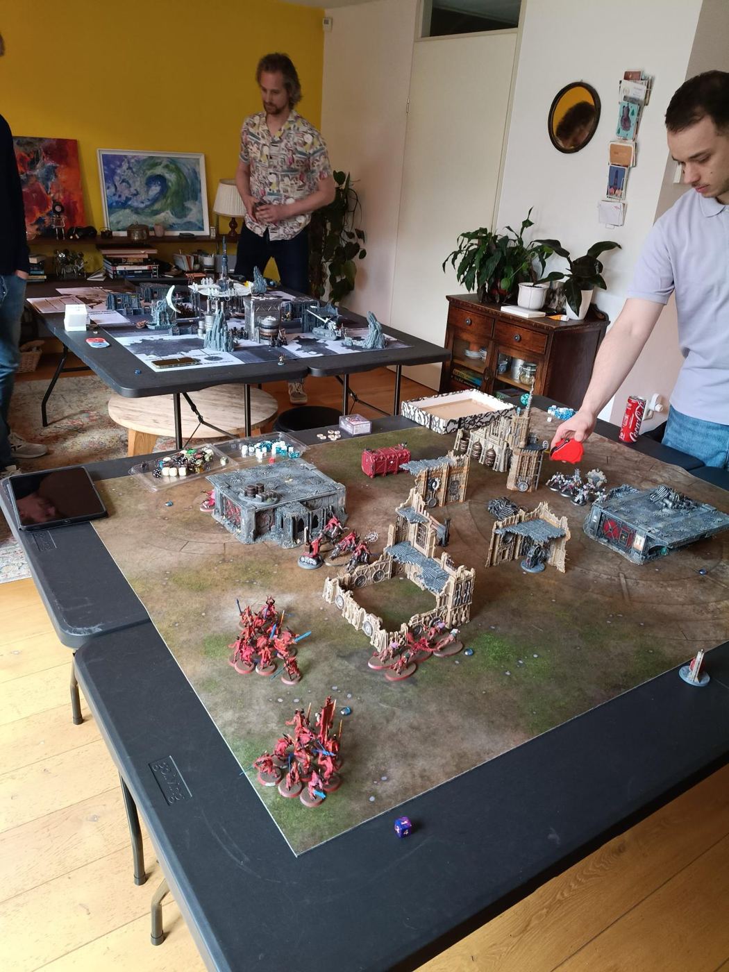 Een Warhammer-slagveld met gebouwen en miniaturen op een grote tafel