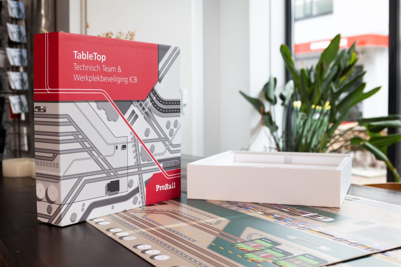 Doos van de tabletop Technisch Team en Werkplekbeveiliging naast de uitgerolde spelondergrond