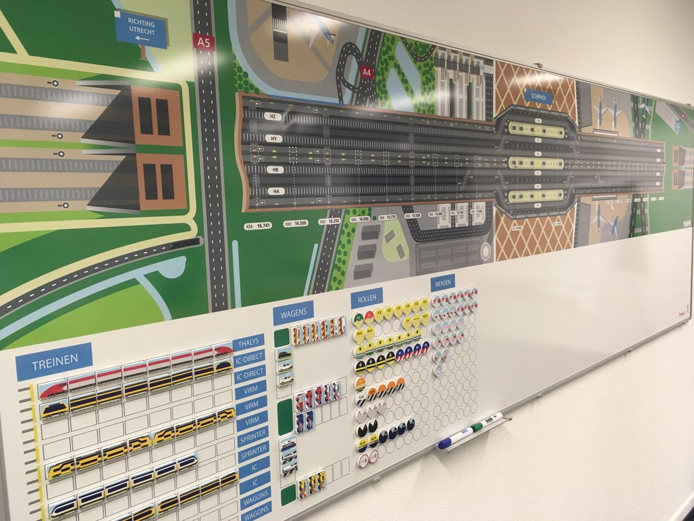 Magnetisch whiteboard met een plattegrond van de Schiphol-tunnel en kolommen vol magneten voor materieel